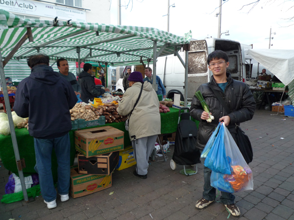 p1000326 Happily pose with his spring onion and ginger that he just bought. Guess what is he going to cook?